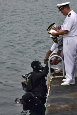 A Navy diver assists with a Pearl Harbor interment